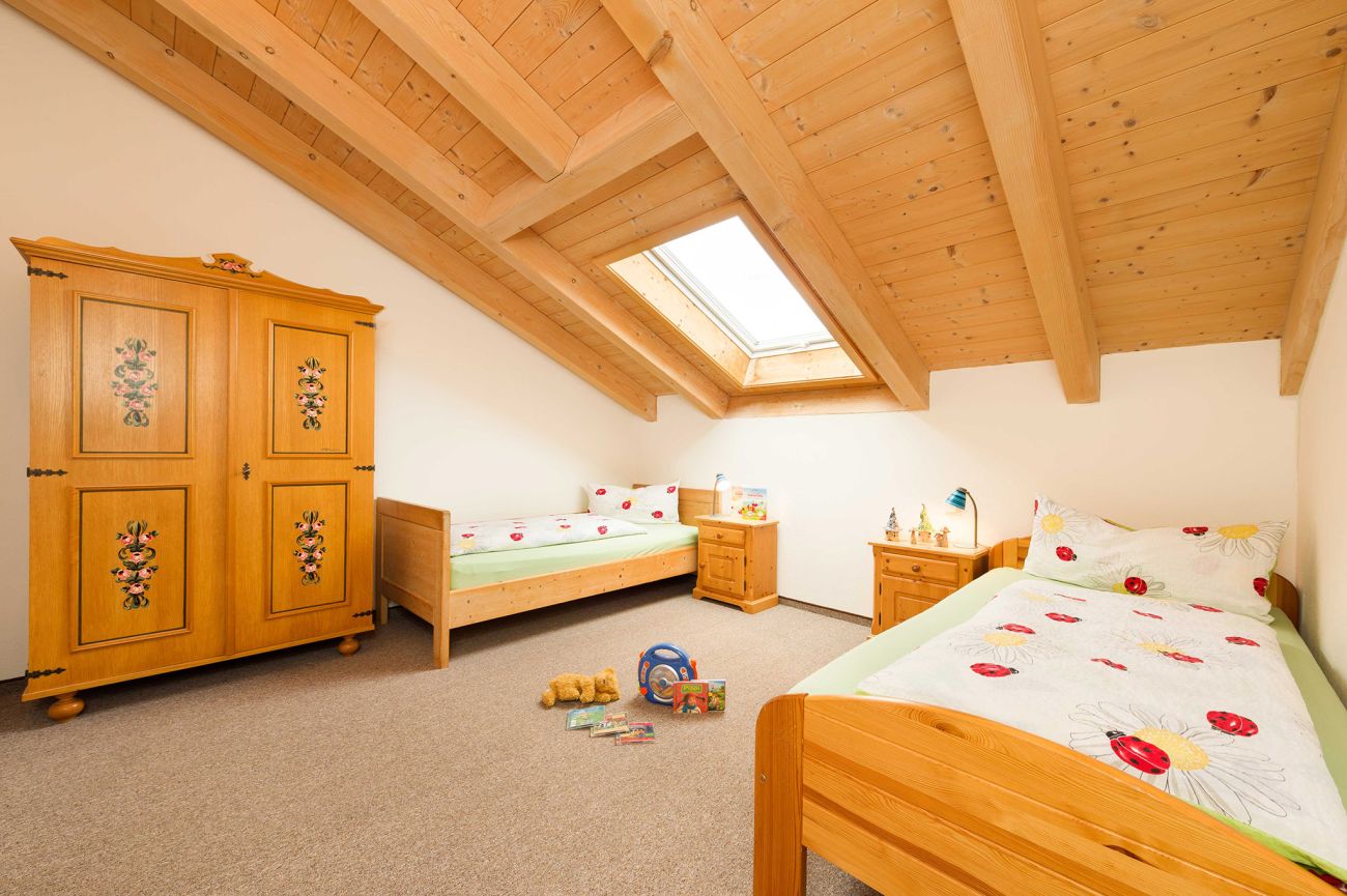 Kinderzimmer mit zwei Einzelbetten in der 5 Sterne Ferienwohnung Aggenstein auf dem Biobauernhof und Pferdehof Schöll im Allgäu